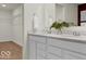 This bathroom provides dual sinks, white cabinets, modern fixtures and leads to a walk-in closet at 5931 Sterling Dr, Whitestown, IN 46075
