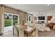Open-concept living and dining area with modern furniture, fireplace, and sliding glass doors to the backyard at 5931 Sterling Dr, Whitestown, IN 46075