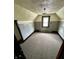 This bedroom features neutral carpeting, paneled walls, natural light, and a unique ceiling in need of some TLC at 600 S Oak St, Fortville, IN 46040