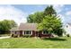 Charming brick home with a well-manicured lawn and mature trees at 6040 Manker St, Indianapolis, IN 46227