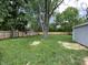 Spacious backyard featuring green grass, a mature tree, and a wood fence at 6150 E 25Th St, Indianapolis, IN 46219
