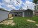 Back exterior showcasing well maintained siding, a lush lawn, and a wood fence at 6150 E 25Th St, Indianapolis, IN 46219
