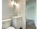 A bright half bathroom with white vanity and toilet, updated with a marble countertop at 6150 E 25Th St, Indianapolis, IN 46219