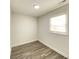 Neutral bedroom with wood look flooring, white walls, and a bright window at 6150 E 25Th St, Indianapolis, IN 46219