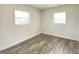 Neutral bedroom with wood look flooring, white walls, and bright windows at 6150 E 25Th St, Indianapolis, IN 46219