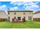 View of a backyard with a spacious lawn, wooden fence, and a deck with chairs and table at 6609 Fountain Springs Blvd, Indianapolis, IN 46236