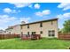 View of the home's back exterior featuring a wooden deck overlooking the spacious, well-manicured lawn at 6609 Fountain Springs Blvd, Indianapolis, IN 46236
