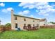 View of a backyard with a spacious lawn, wooden fence, and a deck with chairs and table at 6609 Fountain Springs Blvd, Indianapolis, IN 46236