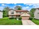 Charming two-story home with a well-manicured lawn and an attached garage at 6609 Fountain Springs Blvd, Indianapolis, IN 46236