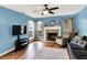 Cozy living room with fireplace, wood floors, and ceiling fan at 6609 Fountain Springs Blvd, Indianapolis, IN 46236