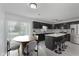 Modern kitchen with black cabinets, stainless steel appliances, and breakfast bar at 6703 Wimbledon Dr, Zionsville, IN 46077