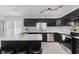 Updated kitchen features an island with seating, modern backsplash, stainless steel appliances, and dark cabinets at 6703 Wimbledon Dr, Zionsville, IN 46077
