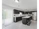 Modern kitchen with stainless steel appliances, dark cabinetry, white countertops, and island with barstool seating at 6703 Wimbledon Dr, Zionsville, IN 46077