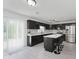 Modern kitchen with black cabinets, stainless steel appliances, and a breakfast bar with seating at 6703 Wimbledon Dr, Zionsville, IN 46077