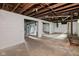 Unfinished basement with exposed beams and painted walls, offering potential for customization at 703 Kappes St, Indianapolis, IN 46221