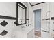 Black and white tiled bathroom featuring a bright vanity and fresh modern mirror at 703 Kappes St, Indianapolis, IN 46221
