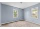 Bedroom with neutral carpet, light blue walls and two windows with natural light at 703 Kappes St, Indianapolis, IN 46221
