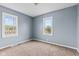Bedroom with neutral carpet, light blue walls and two windows with natural light at 703 Kappes St, Indianapolis, IN 46221