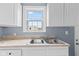 A clean, well lit kitchen with stainless sink, bright window and fresh paint at 703 Kappes St, Indianapolis, IN 46221