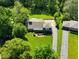 Aerial view of a home featuring a well-maintained lawn, mature trees, and a paved driveway at 7035 Creekside Ln, Indianapolis, IN 46220