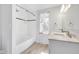 Bathroom featuring double sinks, tiled shower, and wood-look floors at 7035 Creekside Ln, Indianapolis, IN 46220