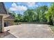 Spacious concrete driveway leading to a well-maintained home with lush greenery and a partial fence at 7035 Creekside Ln, Indianapolis, IN 46220
