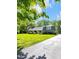 Attractive home with a large front yard, lush greenery, mature trees, and an extended driveway at 7035 Creekside Ln, Indianapolis, IN 46220