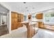 Kitchen featuring an island with seating, wood cabinetry, abundant natural light, and neutral floors at 7035 Creekside Ln, Indianapolis, IN 46220