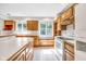 Kitchen with wood cabinets, center island with seating, garden window, and a white appliance, for a bright, functional space at 7035 Creekside Ln, Indianapolis, IN 46220