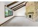 Bright living room with a striking brick fireplace, wood beams, and large window at 7035 Creekside Ln, Indianapolis, IN 46220