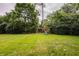 Backyard featuring a swing set with green grass and mature trees at 7887 Meadowbrook Dr, Indianapolis, IN 46240
