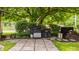 Outdoor cooking area with lush landscaping, stone pavers, and mature tree at 7887 Meadowbrook Dr, Indianapolis, IN 46240