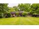 A neatly kept backyard featuring a brick ranch home with well-maintained landscaping at 7887 Meadowbrook Dr, Indianapolis, IN 46240