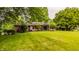 View of the backyard featuring a well-manicured lawn and the rear exterior of the home at 7887 Meadowbrook Dr, Indianapolis, IN 46240