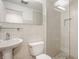 Bright bathroom with tile shower, glass door, toilet and sink at 7887 Meadowbrook Dr, Indianapolis, IN 46240