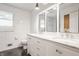 This bathroom features a marble countertop, cabinets, tiled walls, and two well-lit mirrors at 7887 Meadowbrook Dr, Indianapolis, IN 46240
