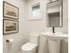 Bathroom featuring a sleek pedestal sink, contemporary toilet, and art deco-style artwork at 7887 Meadowbrook Dr, Indianapolis, IN 46240