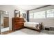 This bedroom features a dresser, mirror and twin bed with natural light from an adjacent window at 7887 Meadowbrook Dr, Indianapolis, IN 46240