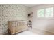 This Bedroom features a wooden crib, chair, shelves and a leafy green wallpaper at 7887 Meadowbrook Dr, Indianapolis, IN 46240