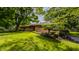 Well-maintained one-story home with brick facade, mature trees, and green lawn at 7887 Meadowbrook Dr, Indianapolis, IN 46240