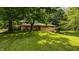 Well-maintained one-story home with brick facade, mature trees, and green lawn at 7887 Meadowbrook Dr, Indianapolis, IN 46240