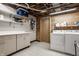 Well-lit laundry room with washer, dryer, utility sink and wood paneling at 7887 Meadowbrook Dr, Indianapolis, IN 46240
