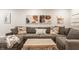 Basement living room with plush grey sofa, natural wood coffee table and unique wall decor at 7887 Meadowbrook Dr, Indianapolis, IN 46240