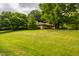 Beautiful tree-lined yard showcasing the home's exterior, offering privacy and a serene setting at 7887 Meadowbrook Dr, Indianapolis, IN 46240