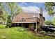 Exterior view of a two-story home with a large wooden deck and a stone foundation at 8024 Sunfield Ct # 5-B, Indianapolis, IN 46214