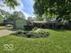 Charming single-story home with an attached garage, manicured lawn and landscaped flower beds at 8206 Bull Run Ct, Indianapolis, IN 46227