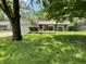 Charming single-story home with mature trees, landscaped yard, and American flag waving proudly at 8206 Bull Run Ct, Indianapolis, IN 46227