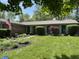 Beautiful single-story brick home with large front yard, manicured lawn, and colorful flower beds at 8206 Bull Run Ct, Indianapolis, IN 46227
