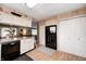 Cozy kitchen with white cabinets, black appliances, and a view into an adjoining room at 8206 Bull Run Ct, Indianapolis, IN 46227