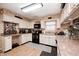 Traditional kitchen showcasing white cabinets, a black range, and light wood-look flooring at 8206 Bull Run Ct, Indianapolis, IN 46227